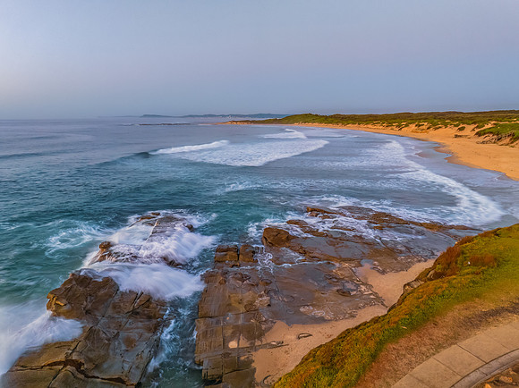 Sunrise over the sea and rocks with clear skies