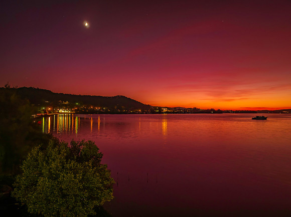 Colours of Dawn over the bay with boats and high cloud