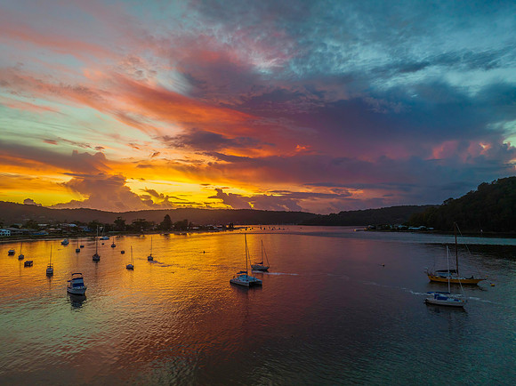 Aerial sunrise waterscape with boats, colour and clouds
