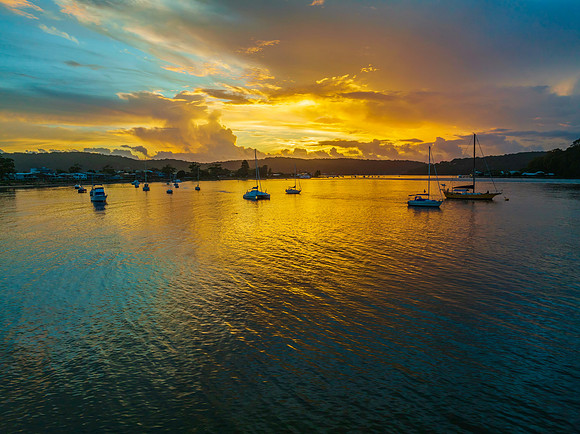 Aerial sunrise waterscape with boats, colour and clouds