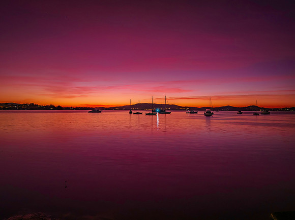 Pink dawn with boats and high cloud