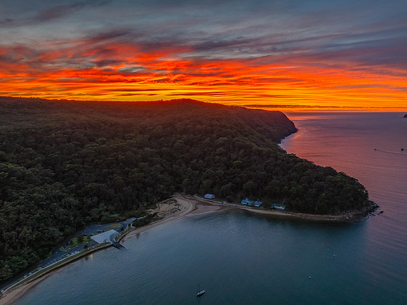Sunrise over the bay with boats and cloud covered sky