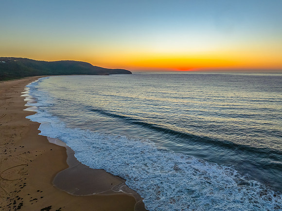 Sunrise seascape with clear skies and orange horizon