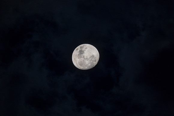 Waxing gibbous moon in the cloud covered evening sky