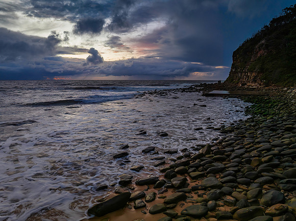 Moody sunrise seascape with rain clouds