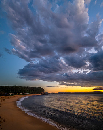 Sunrise over the ocean with clouds and a calm sea