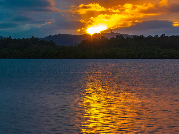The sun trying to burst through the rain clouds and shine over t