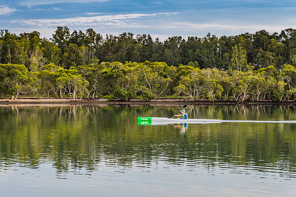 Early morning rower waterscape with reflections