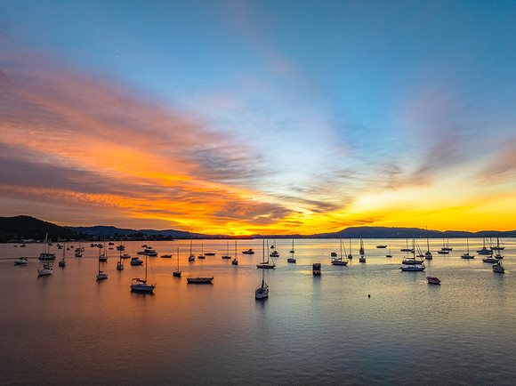 Aerial sunrise waterscape with boats and high cloud