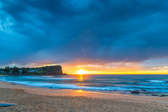 Winter sunrise by the sea shore with rain clouds