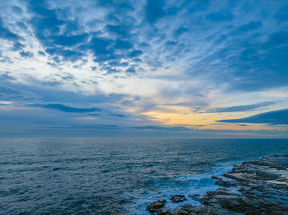 Dreamy soft-hued sunrise seascape over the ocean with high cloud