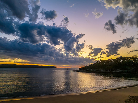 Sunrise over the ocean with clouds and a calm sea