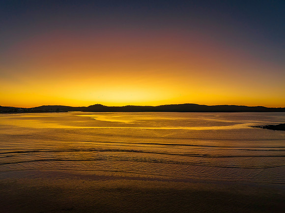 Aerial sunrise seascape with orange glow on a cold Winter's morn
