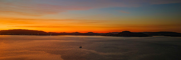 Aerial sunrise waterscape with boats and high cloud