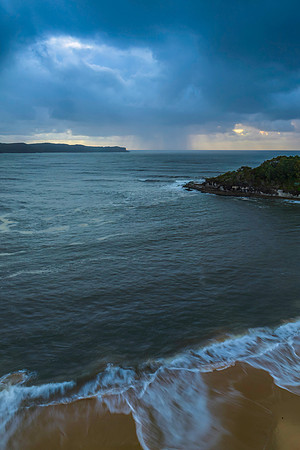 Sunrise seascape with overcast sky and rain clouds