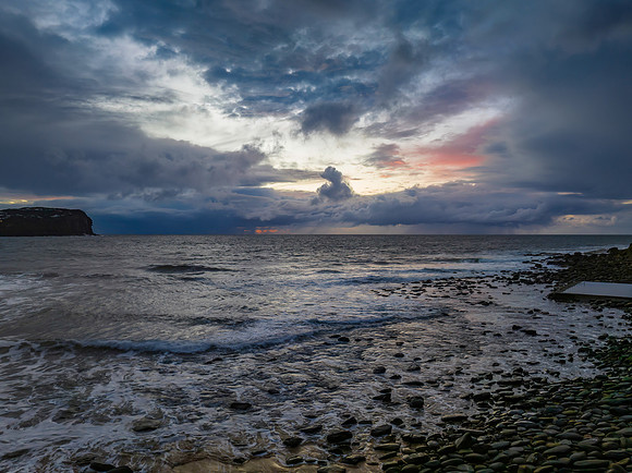 Moody sunrise seascape with rain clouds