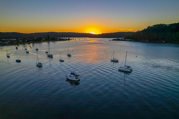 Aerial sunrise waterscape with boats and clear skies