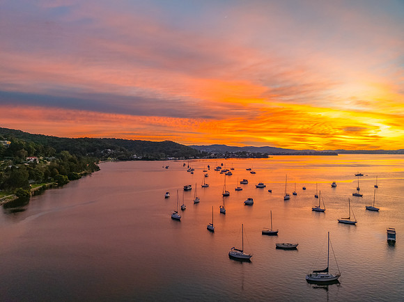 Aerial sunrise waterscape with boats and high cloud
