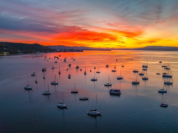 Aerial sunrise waterscape with boats and high cloud