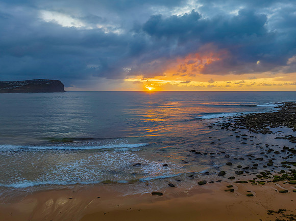 Drizzly moody sunrise seascape with cloud filled sky
