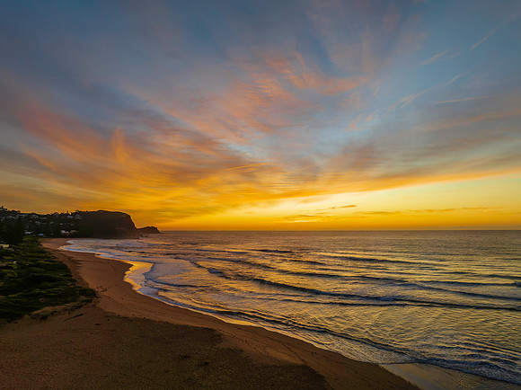 Sunrise and high cloud cover over the sea