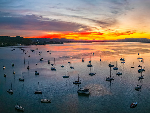 Aerial sunrise waterscape with boats and high cloud