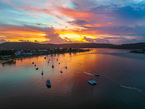 Aerial sunrise waterscape with boats, colour and clouds