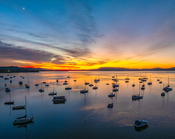 Aerial sunrise waterscape with boats and high cloud
