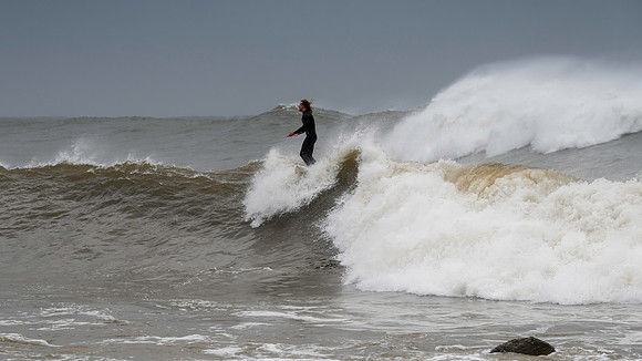 Surfer catching a wave in the rain