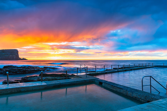 Winter sunrise by the sea pool with rain clouds