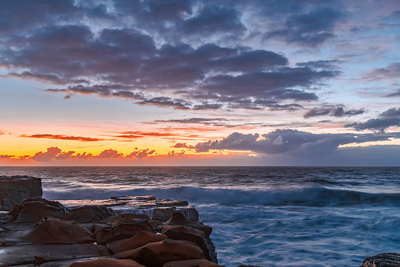 Sunrise, sea, waves, clouds and tessellated rock platform