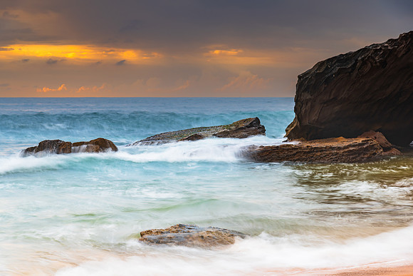 Sunrise at the seaside with rocks and beautiful diffused light b