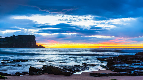 Winter sunrise by the sea shore with rain clouds