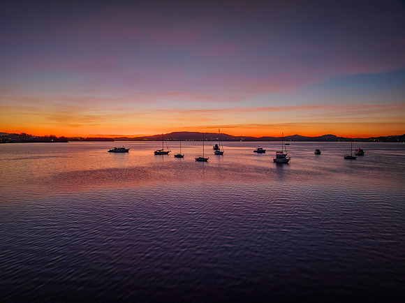 Aerial sunrise waterscape with boats and high cloud