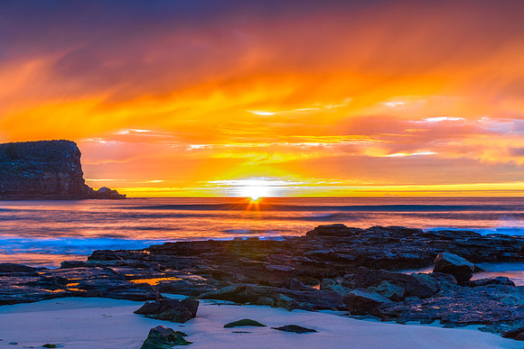 Winter sunrise by the sea shore with rain clouds