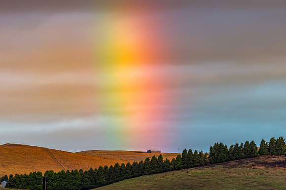Sunset rainbow shining through the storm clouds