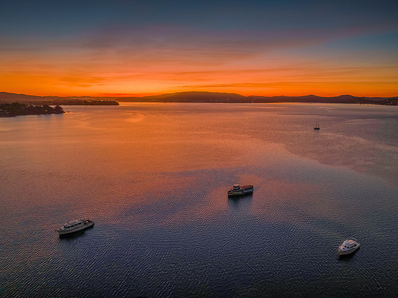 Aerial sunrise waterscape with boats and high cloud