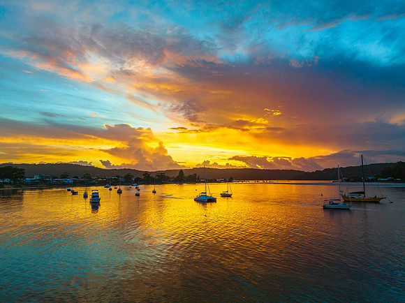 Aerial sunrise waterscape with boats, colour and clouds