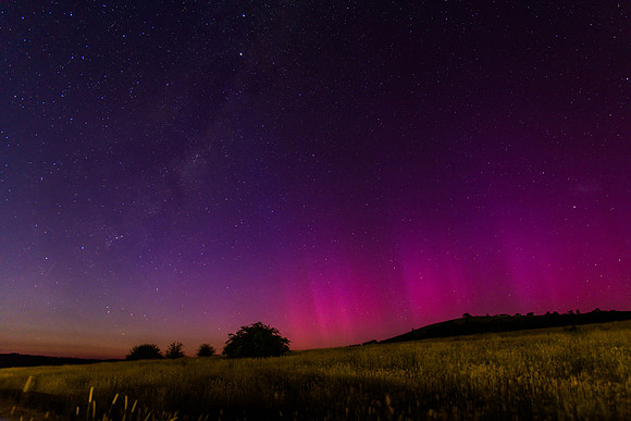 Aurora Australis display lights up the predawn sky in pinks