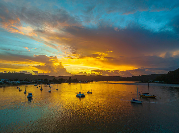Aerial sunrise waterscape with boats, colour and clouds