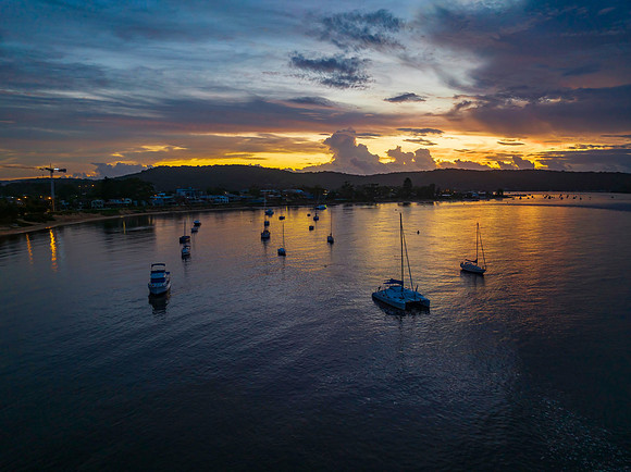 Aerial sunrise waterscape with boats, colour and clouds