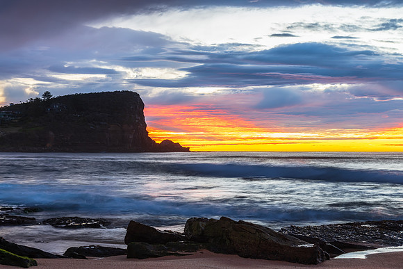 Winter sunrise by the sea shore with rain clouds