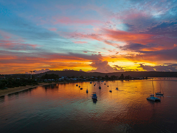 Aerial sunrise waterscape with boats, colour and clouds