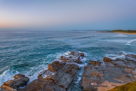 Sunrise over the sea and rocks with clear skies