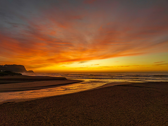 Sunrise and high cloud cover by the sea and lagoon