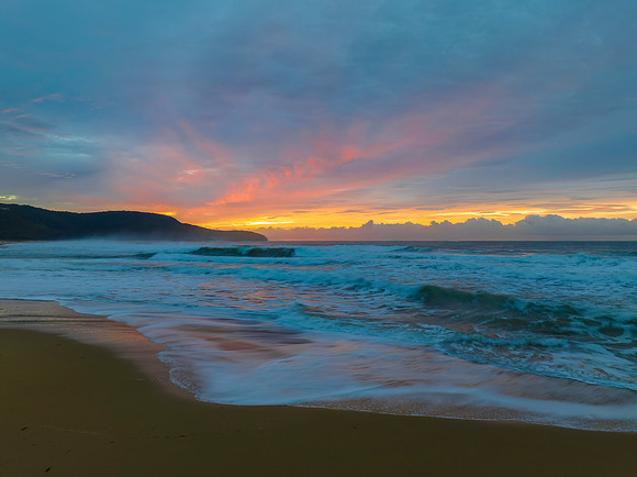 Cloud covered sunrise at the seaside in soft pastel shades