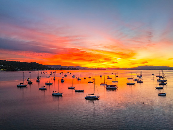 Aerial sunrise waterscape with boats and high cloud