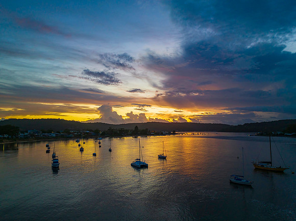Aerial sunrise waterscape with boats, colour and clouds