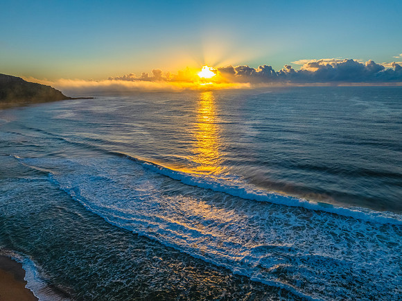 Sunrise over the sea with a low cloud bank and fog
