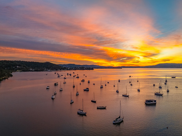 Aerial sunrise waterscape with boats and high cloud